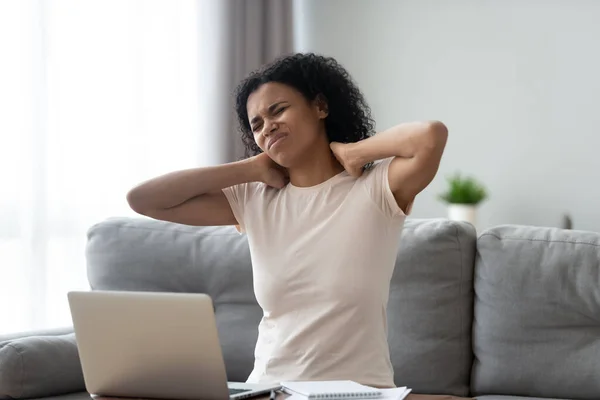 Unhappy African American woman massaging neck, suffering from pain