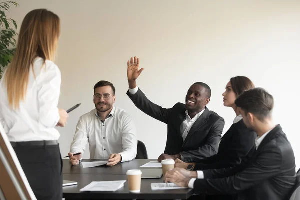 Motivated biracial male employee raise hand answering at team training — Stock Photo, Image