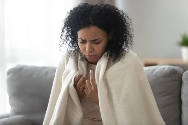 Unhappy sick African American woman covered with warm blanket — Stock Photo, Image