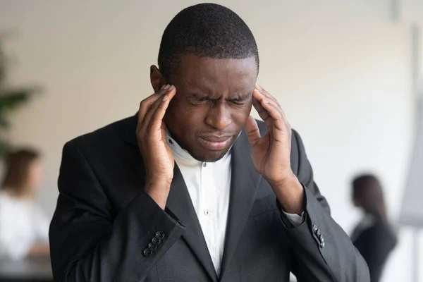 Close-up van gestresste biraciale zakenman die last heeft van hoofdpijn — Stockfoto
