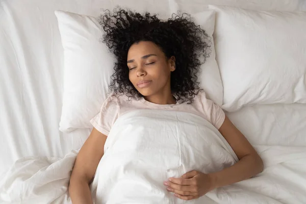 Wanita Afrika-Amerika yang tenang tidur dengan pandangan atas tempat tidur yang nyaman — Stok Foto