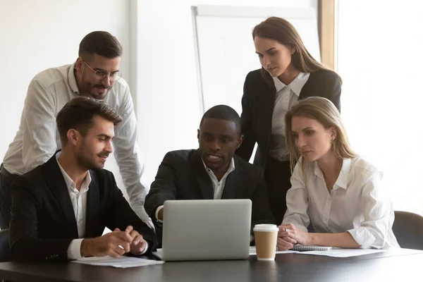 Serious multiracial colleagues discuss project working on laptop — Stock Photo, Image