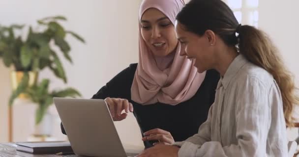 Mentore musulmana femminile aiutare tirocinante caucasico spiegando il lavoro al computer — Video Stock