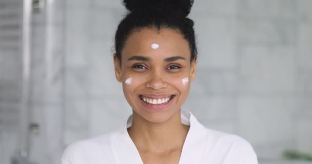 Šťastný mladý africký žena reklama tvář krém pohled na kameru — Stock video