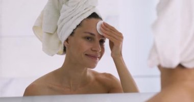 Mutlu genç kadın pamuk bloknotu tutuyor yüz derisini temizliyor