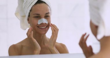 Mutlu çekici genç kadın burun bantlarını temizler siyah gözenekleri