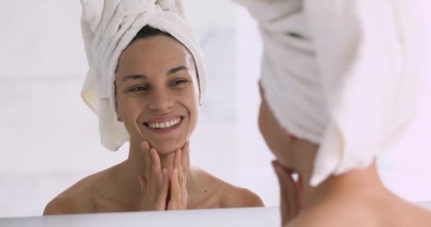 Smiling pretty young woman with towel on head touching face — Stock Video