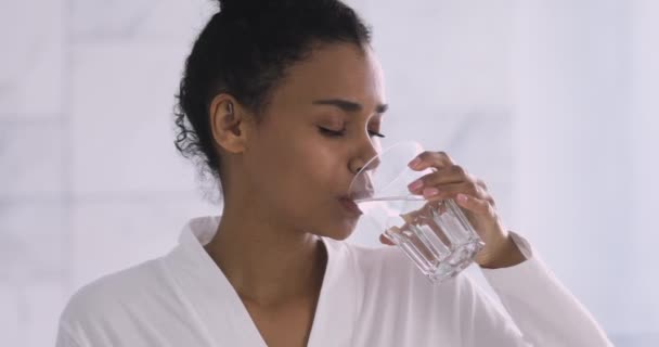 Vacker frisk afrikansk kvinna dricker färskt mineralvatten på morgonen — Stockvideo
