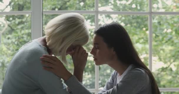 Caring young daughter comforting crying grieving old mother giving empathy — Stock Video