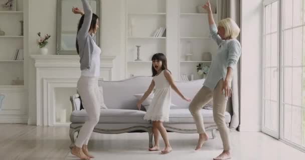 Grappige drie leeftijden generatie vrouwen familie dansen in de woonkamer — Stockvideo