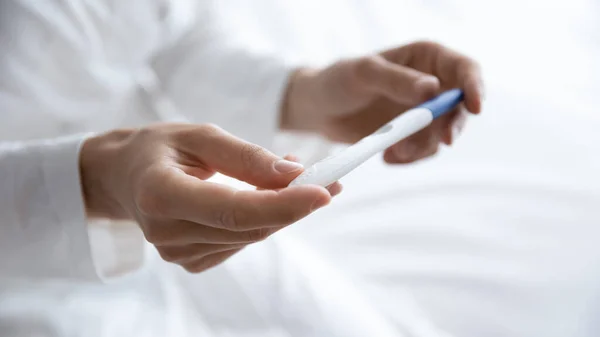 Young woman hold pregnancy test in hands, close up view — Stock Photo, Image