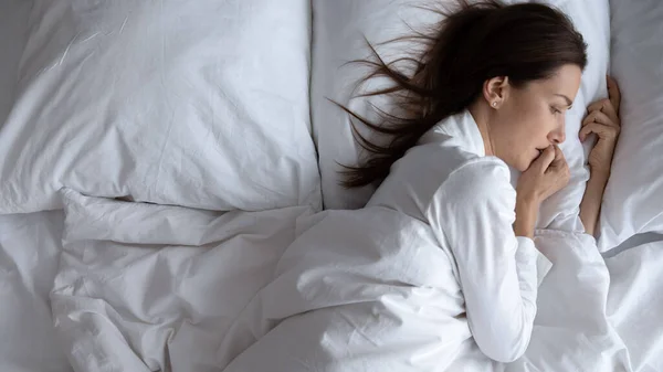 Awoken ketakutan wanita kesepian berbaring di tempat tidur saja, pandangan atas — Stok Foto