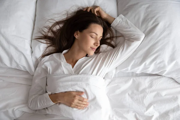 Rustige mooie dame ontspannen slapen in gezellig bed, bovenaanzicht — Stockfoto