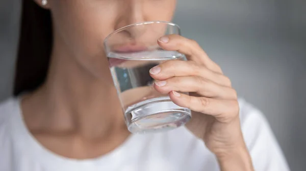 Giovane bella signora in possesso di vetro sorseggiando acqua fresca pura, primo piano — Foto Stock