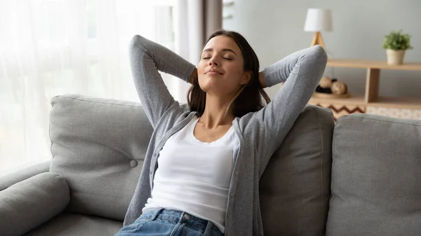 Ontspannen serene jonge vrouw lounge op comfortabele bank thuis — Stockfoto