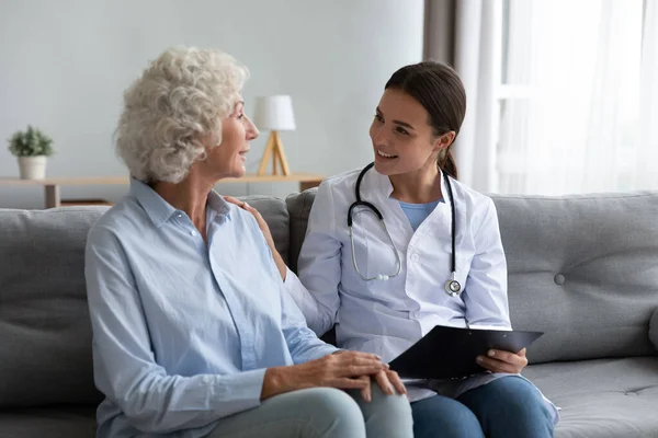 Caring young woman nurse helping supporting old adult grandmother patient — Stock Photo, Image