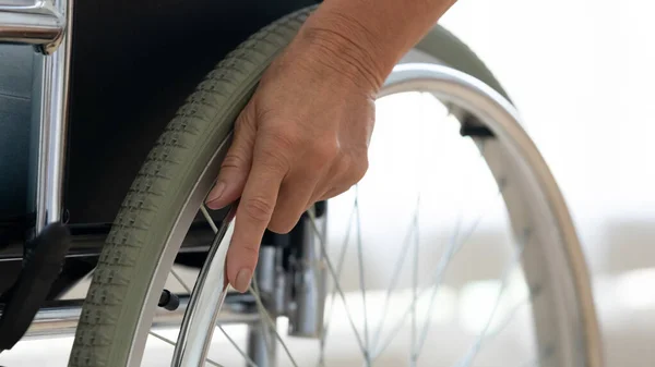 Senior disabled person hand holding pushing wheel close up view — Stock Photo, Image