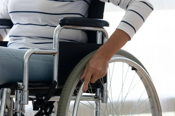 Deficiente idosa empurrar roda sentar na cadeira de rodas, close-up — Fotografia de Stock