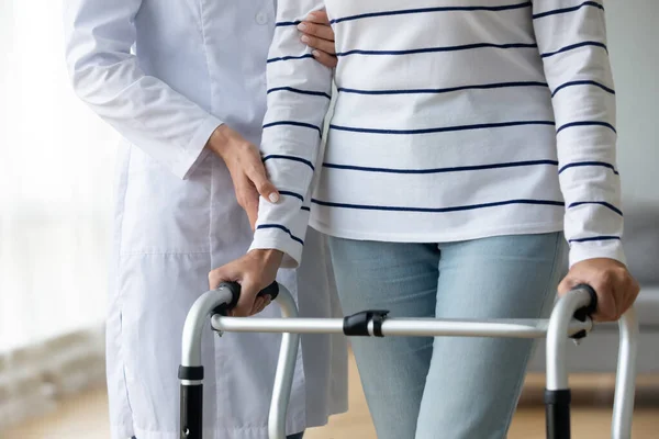 Enfermeira ajudando a velha avó paciente usando quadro de caminhada, close-up — Fotografia de Stock