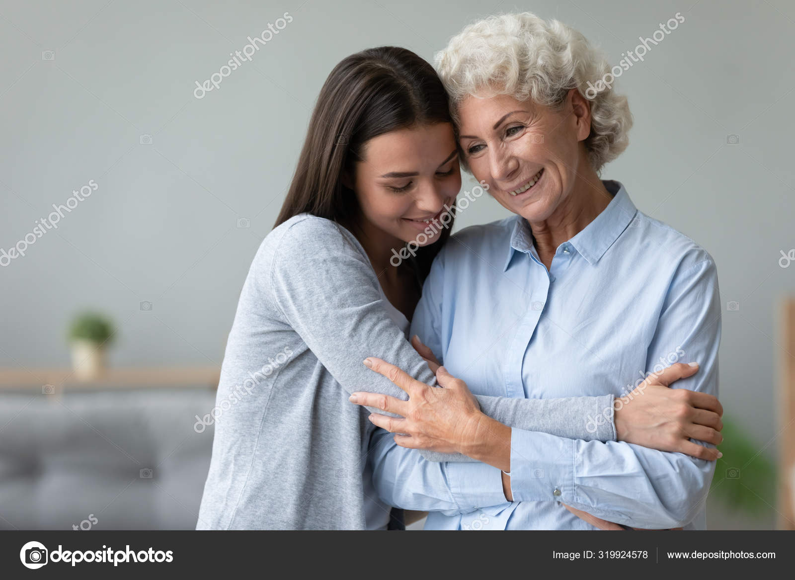Caring young granddaughter hug old granny stand at Stock Photo ©fizkes 319924578