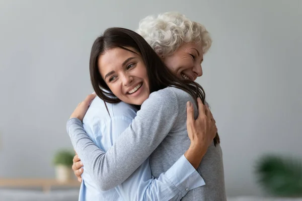 Щаслива молода бабуся обіймає стару бабусю на пенсії — стокове фото