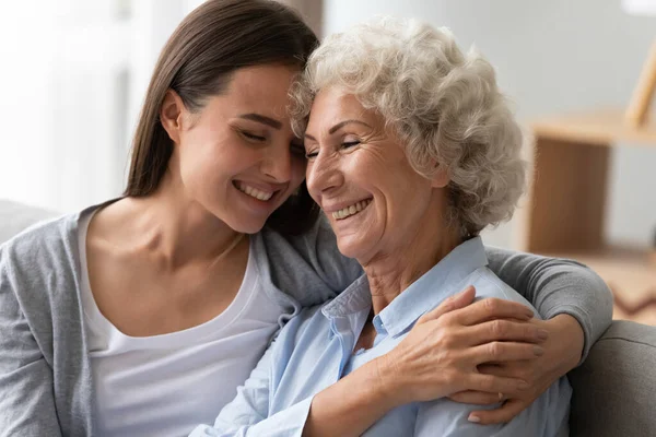 Позитивна стара бабуся і молода онука зв'язуються вдома — стокове фото