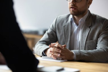 Genç işadamının ellerini kenetleyerek masada oturmasını sağla..