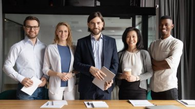 Kendine güvenen takım liderinin portresi meslektaşlarıyla duruyor..