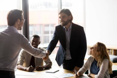 Mutlu işadamları müşterilerle el sıkışıyor, selamlaşıyor ya da anlaşma yapıyor..