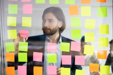 Kanban yönetim kurulunun yanında duran kafaya nişan almış genç profesyonel..