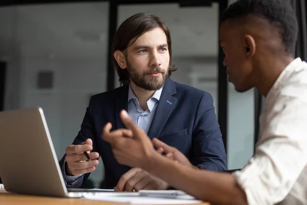 Focused businessman listening to young african american employee. — Stock Photo, Image