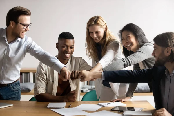 Feliz mezcla de raza más viejo y más joven colegas golpeando puños . — Foto de Stock