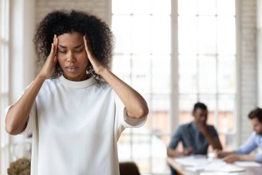 Afrikalı etnik şirket çalışanı şiddetli baş ağrısı hissediyor.