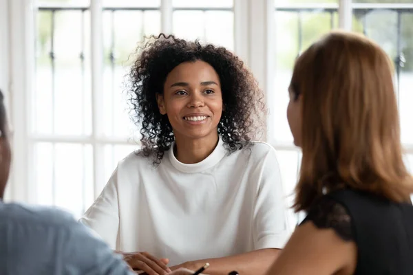 Sourire jeune femme d'affaires afro-américaine parlant avec divers clients . — Photo