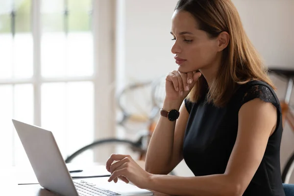 Jeune femme d'affaires réfléchie regardant le moniteur d'ordinateur . — Photo