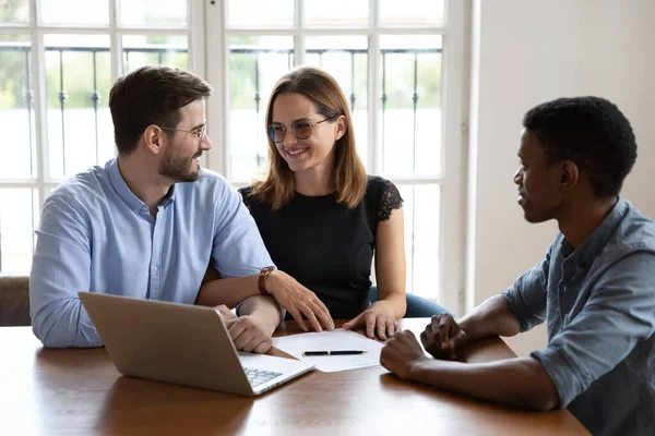 Happy young family couple discussing offer of african american agent. — Stock Photo, Image