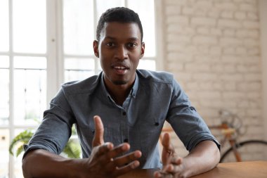 Odaklanmış genç Afro-Amerikan erkek konuşmacı eğitici konferans kaydediyor.