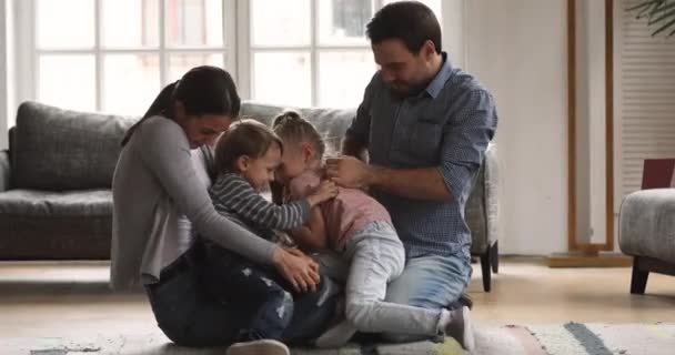 Lycklig mamma pappa leker med barn kittlande skrattar på golvet — Stockvideo