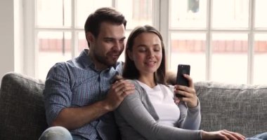 Mutlu genç çift evde akıllı telefon sosyal medya uygulamaları kullanıyor.