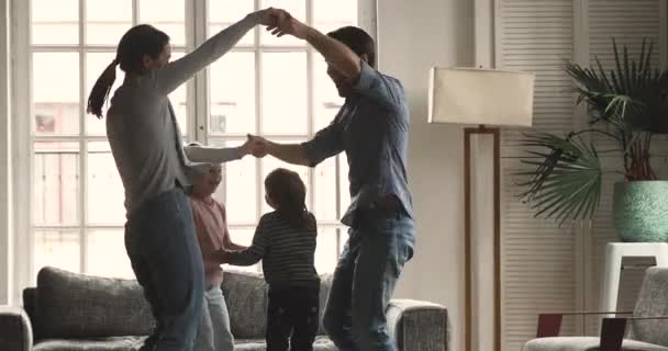 Felices padres despreocupados y niños disfrutando bailando juntos en casa — Vídeo de stock