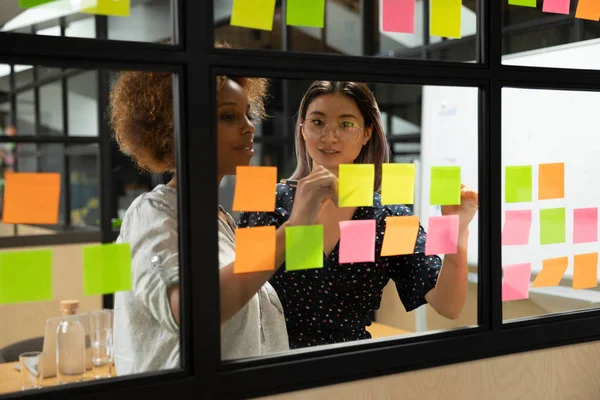 Afrikaans amerikaans jong vrouw scrum master werken met Vietnamese collega. — Stockfoto