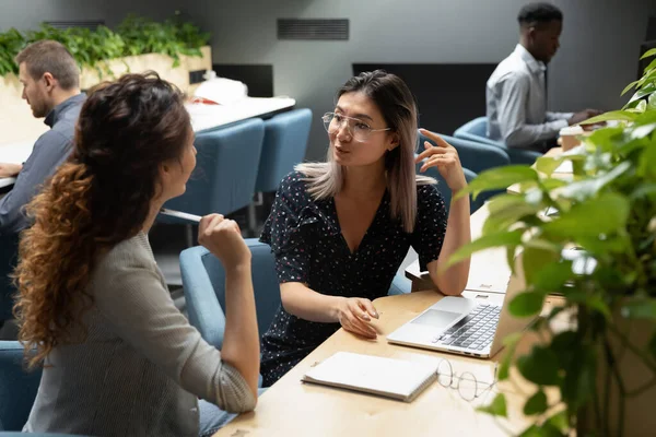 Young vietnamese manager in eyeglasses discussing project details with colleague. — Stock Photo, Image