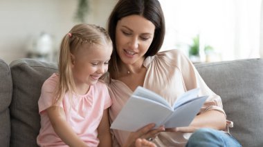 Hoş, genç bir anne kızıyla birlikte peri masalları okuyor..