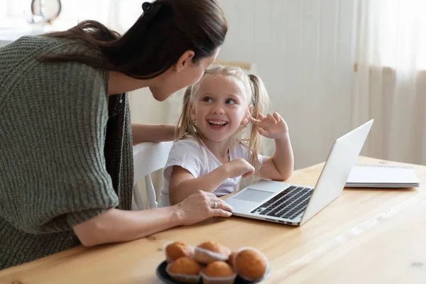 Ung mamma kontrollerar små barn datoranvändning. — Stockfoto