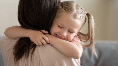 Anaokulunun küçük sevimli kızı annesini kucaklıyor..