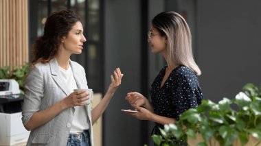 Ofiste çeşitli çalışanlar kahve molası sırasında sohbet ediyorlar..