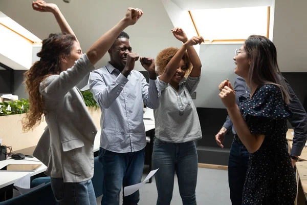 Överlycklig multiracial team medlemmar njuter av fest i moderna coworking office. — Stockfoto