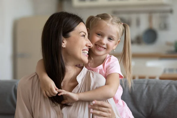 Niña preescolar abrazos de espalda sonriente joven madre . —  Fotos de Stock