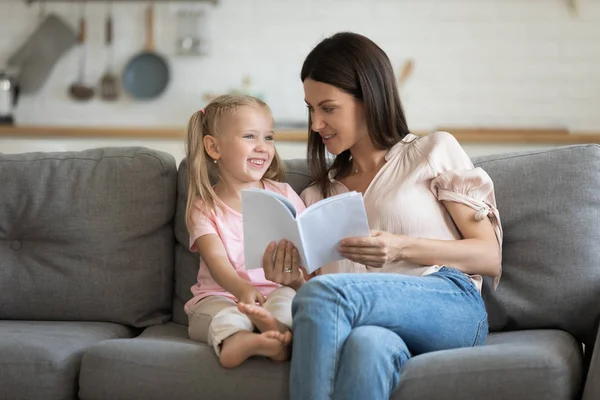 Happy little child girl reading interesting books with mom. — Stok Foto