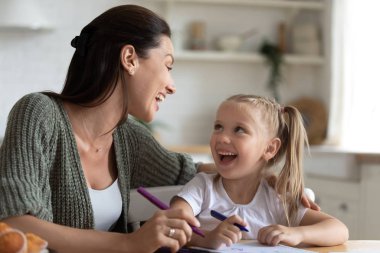 Resim dersi sırasında annesiyle iletişim kuran küçük bir kız..